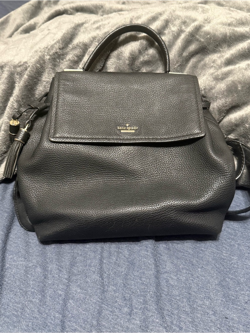 kate spade Black Pebbled Leather Flap Backpack with Tassel